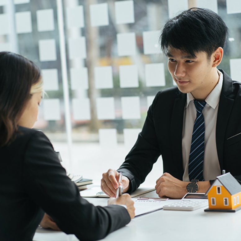 Young married couple carrying cardboard box in front of their new home on moving day Young married couple carrying cardboard box in front of their new house on moving day
